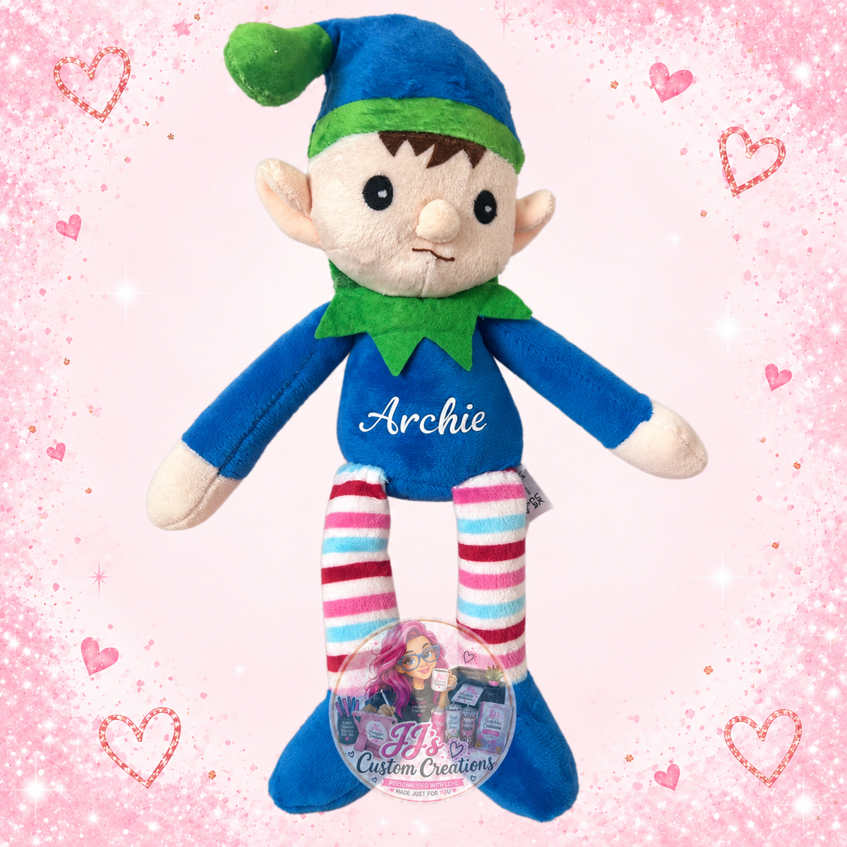Archie blue and green personalised plush elf on JJ’s blush pink sparkle background