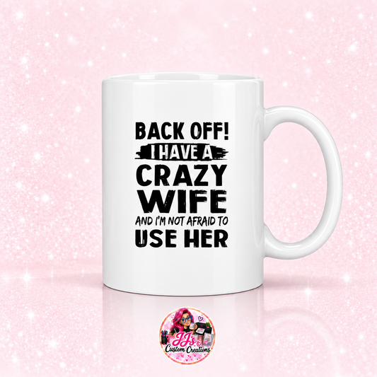 Crazy Wife ceramic mug on a light pale blush background with JJ's Custom Creations pink-haired logo