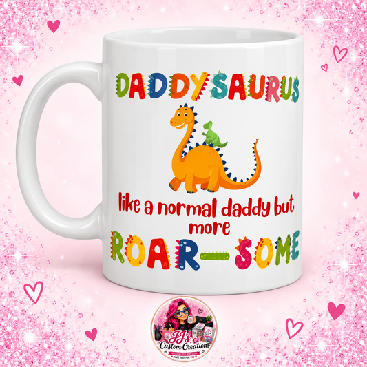 Daddysaurus ceramic mug with colourful dinosaur design on JJ's Custom Creations pink sparkle background