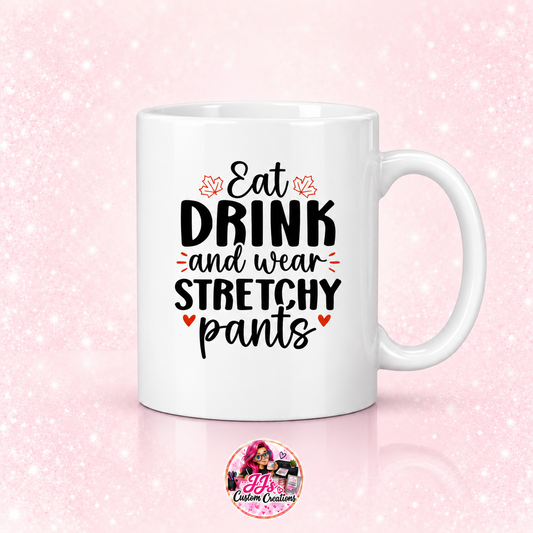 Eat Drink and Wear Stretchy Pants mug on a light pale blush background with JJ's Custom Creations pink-haired logo