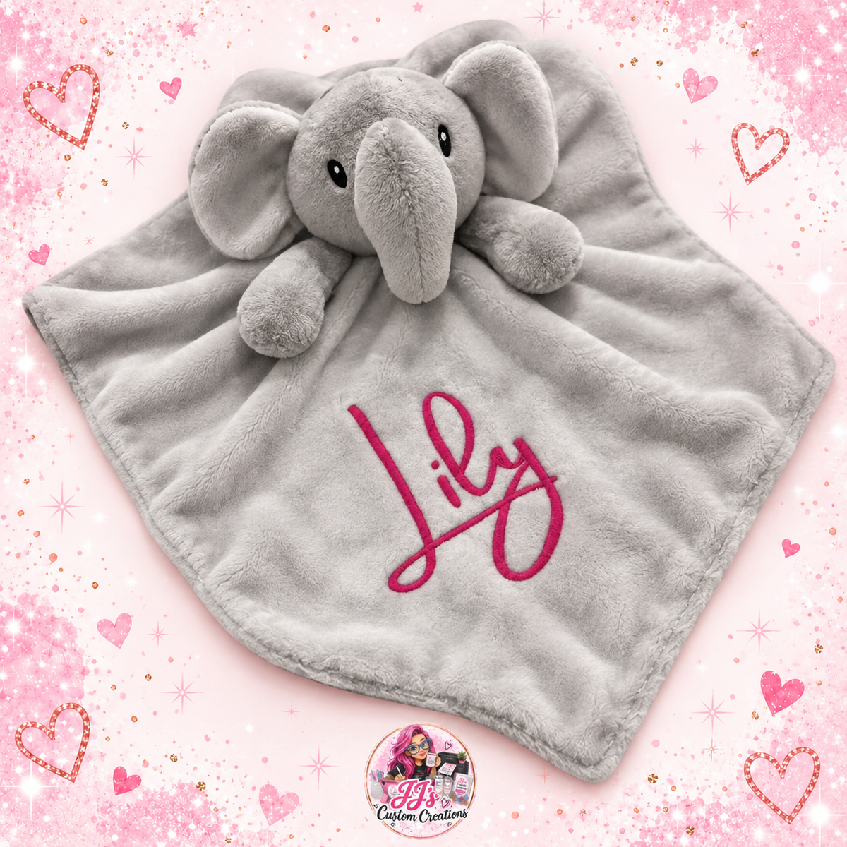 Grey personalised elephant comforter with the name Lily on a pale pink sparkle background with JJ's watermark