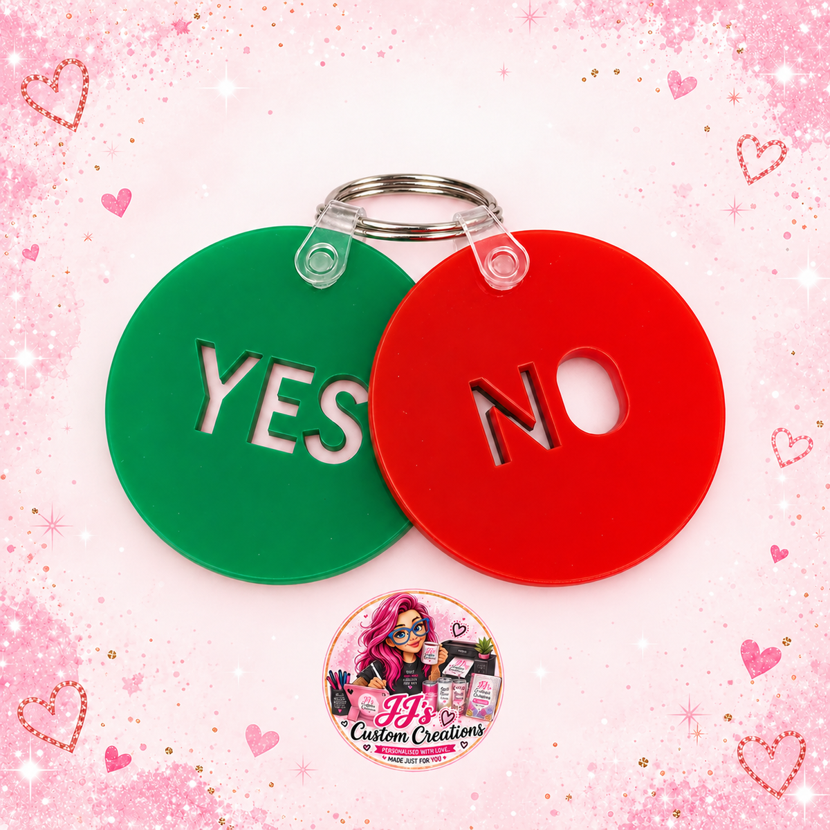 Green YES and red NO acrylic communication keyrings on a full square pale pink sparkle background with JJ's watermark